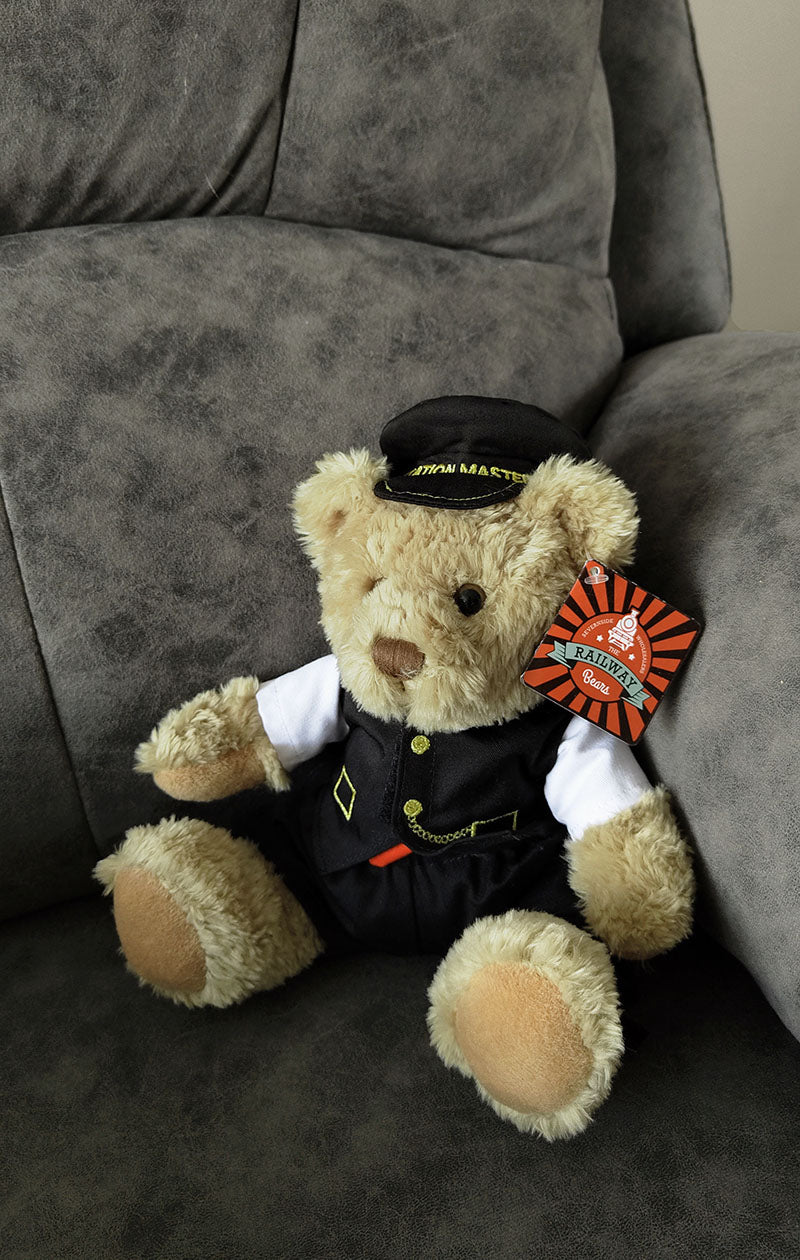 A keel soft toy cuddly stuffed bear with blonde fur and a Station Master embroidered cap.